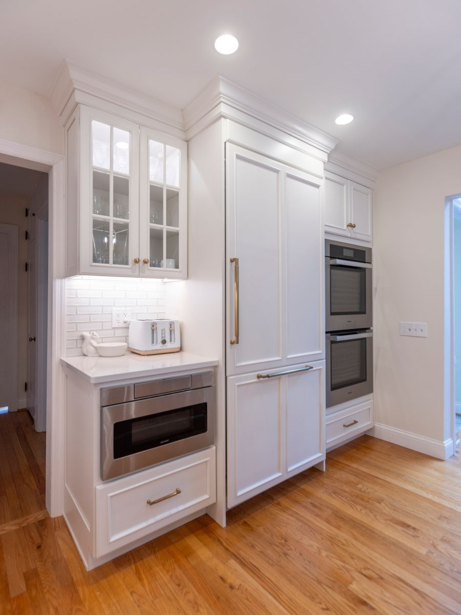 A kitchen with white cabinets and stainless steel appliances