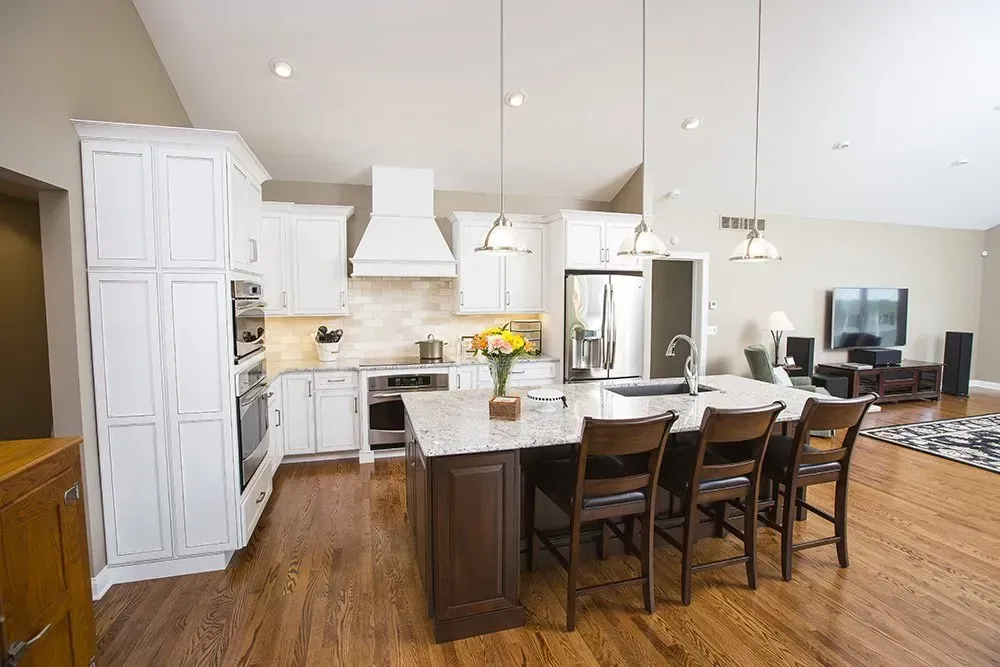 A kitchen with white cabinets and stainless steel appliances and a large island.