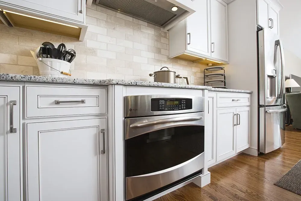 A kitchen with white cabinets and stainless steel appliances.