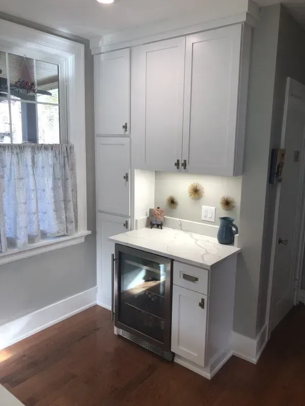 A kitchen with white cabinets and a stainless steel oven
