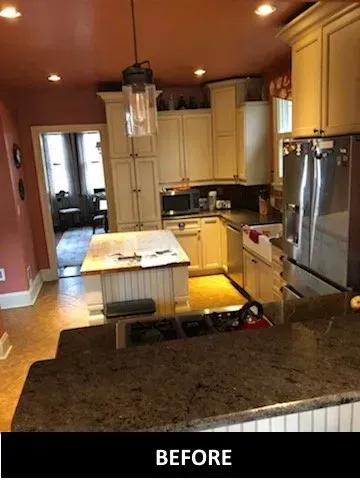 A before picture of a kitchen with white cabinets and stainless steel appliances.