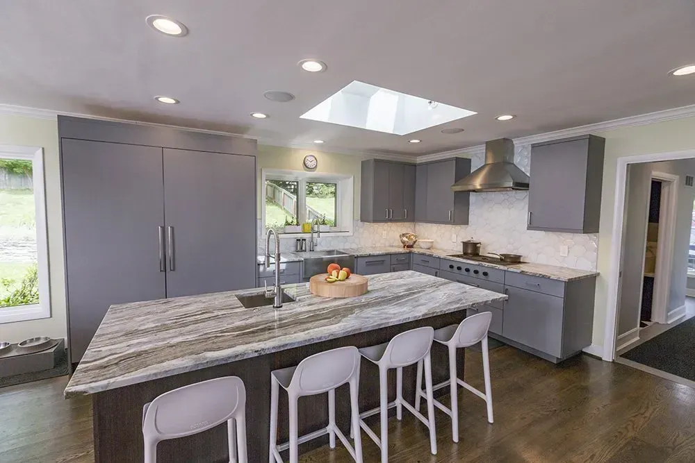 A kitchen with a large island and a skylight in the ceiling.