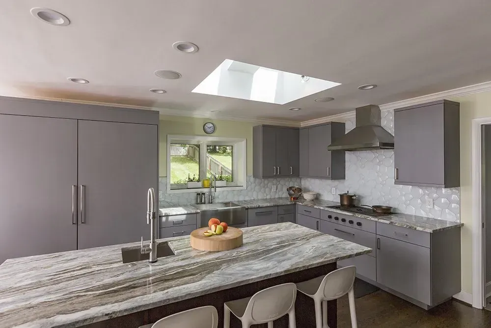 A kitchen with a large island and a skylight in the ceiling.
