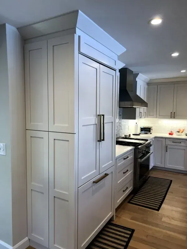 A kitchen with white cabinets and stainless steel appliances