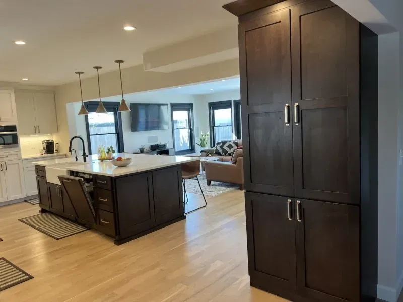 A kitchen with wooden cabinets and a large island in the middle of the room.