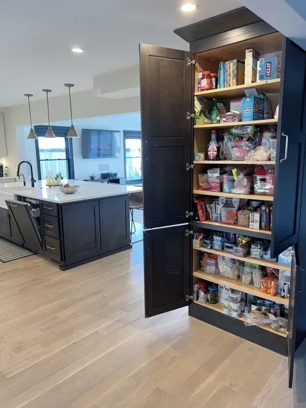 A kitchen with a pantry filled with lots of food.