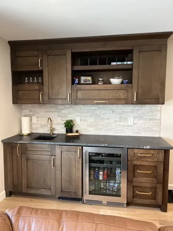A kitchen with wooden cabinets and a stainless steel refrigerator.