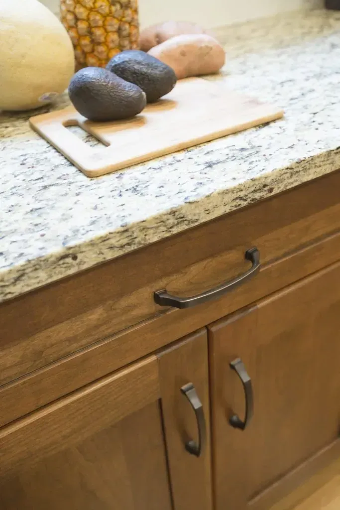 A kitchen counter with a cutting board and avocados on it.