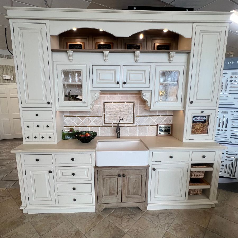A kitchen with white cabinets and a white sink