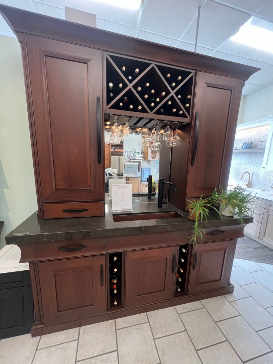 A large wooden cabinet with a wine rack and a sink in a kitchen.