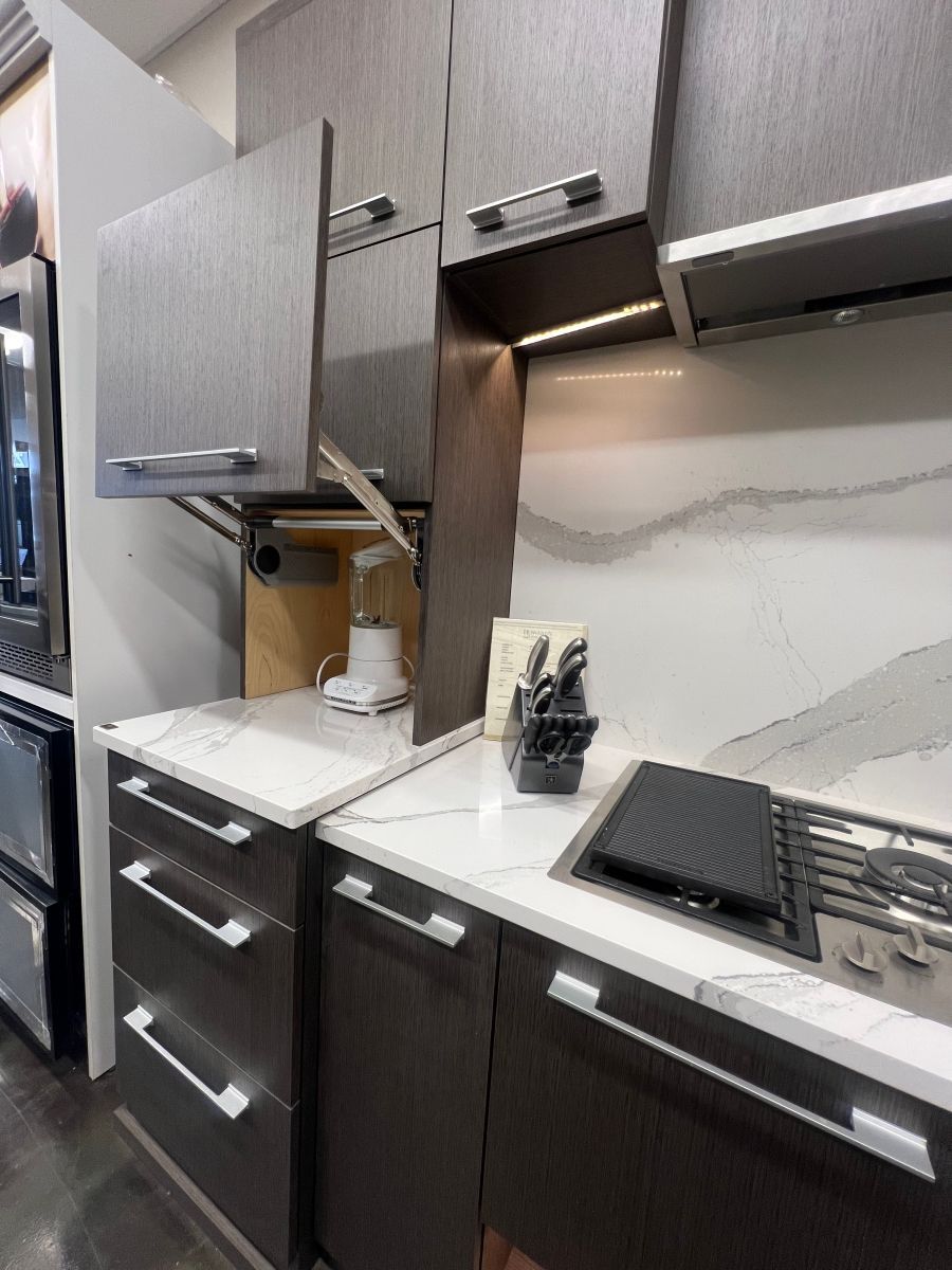 A kitchen with a stove top oven , a microwave , and a blender.