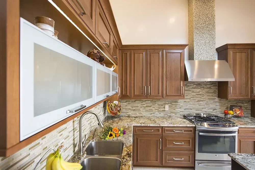 A kitchen with wooden cabinets , stainless steel appliances , a sink and a stove.