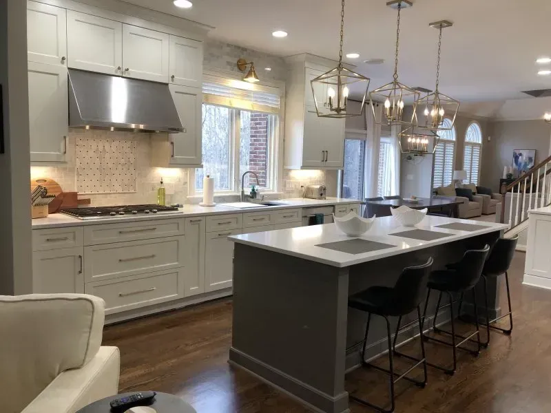 A kitchen with white cabinets and a large island in the middle.
