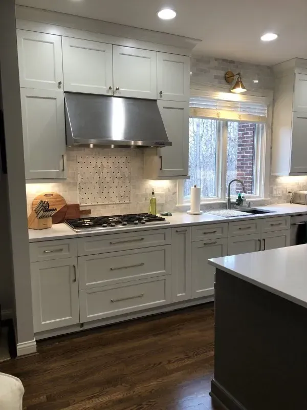 A kitchen with white cabinets and stainless steel appliances