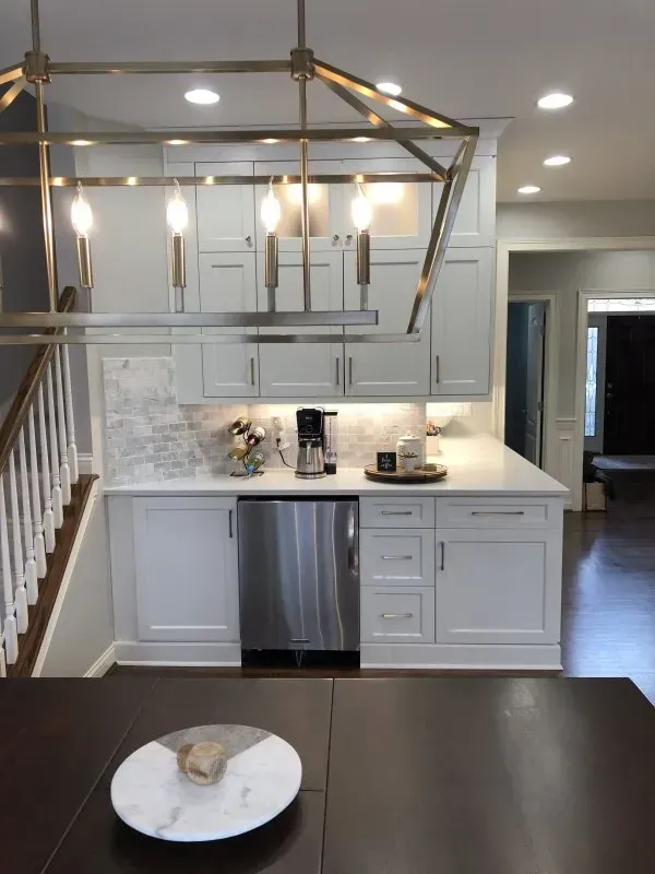 A kitchen with white cabinets and a stainless steel dishwasher