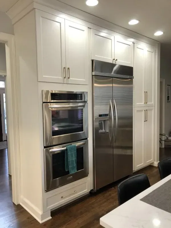 A kitchen with stainless steel appliances and white cabinets