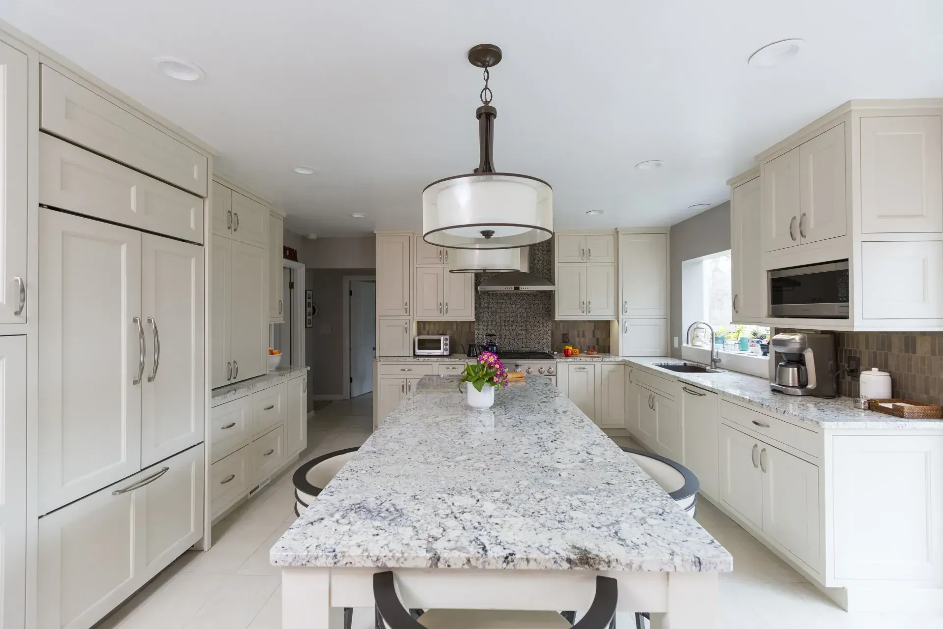 A kitchen with white cabinets and granite counter tops