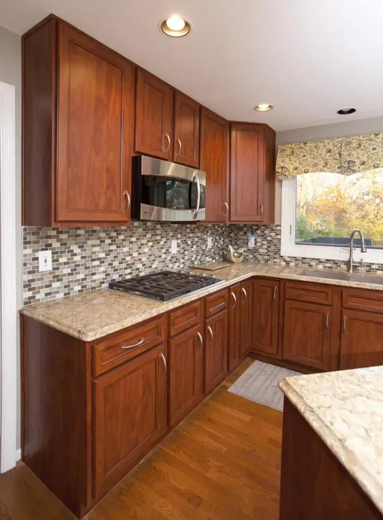 A kitchen with wooden cabinets and granite counter tops.