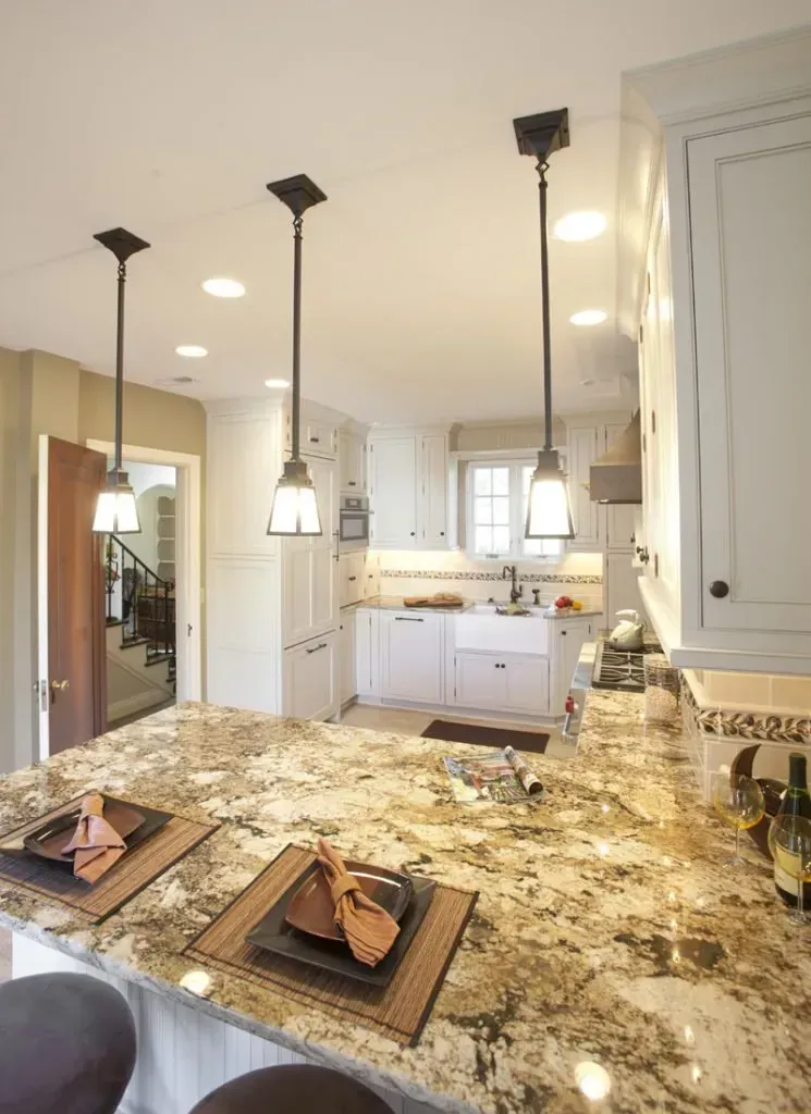 A kitchen with granite counter tops and white cabinets