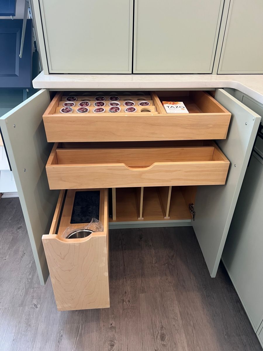 A wooden drawer in a cabinet with the door open