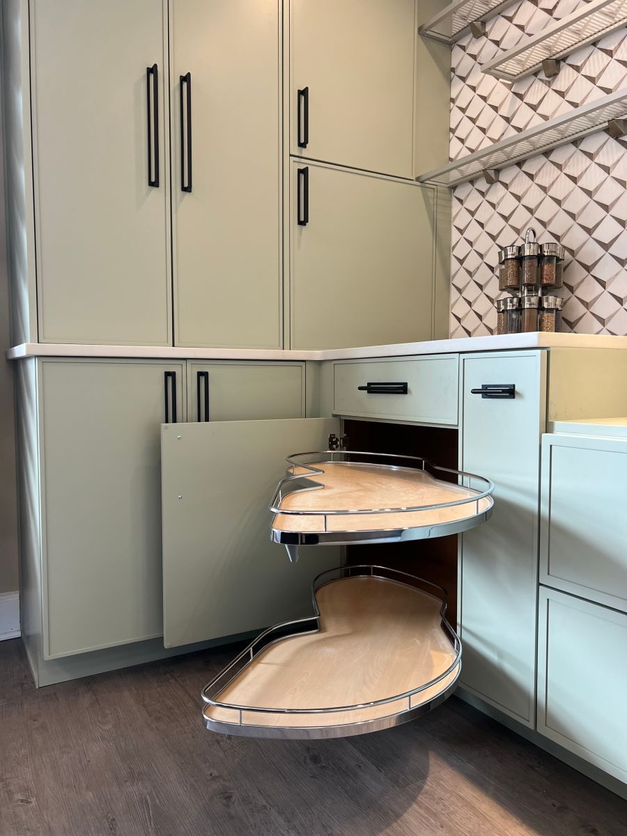 A kitchen with a corner shelf that is pulled out of the cabinet.