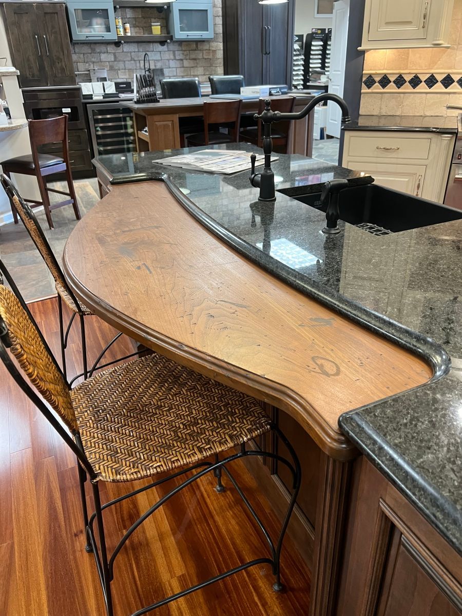 A kitchen with a curved counter top and a sink.