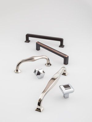 A group of cabinet handles and knobs on a white surface.