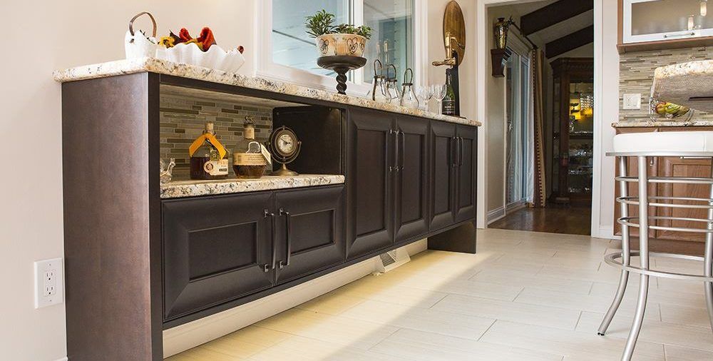 A kitchen with a long counter and a bar.