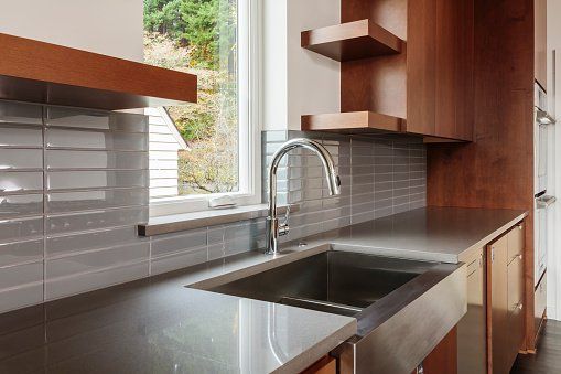A kitchen with white cabinets and a laptop on the counter.