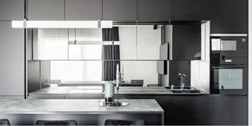 A black and white kitchen with a large island in the middle.