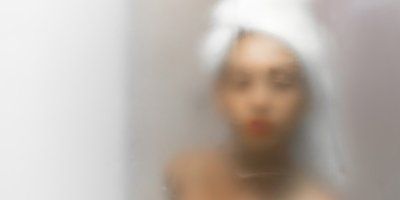 A blurry picture of a woman with a towel wrapped around her head.