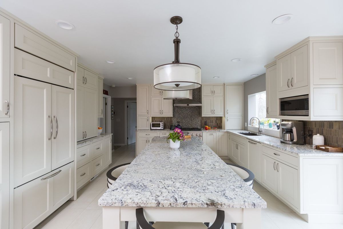 A kitchen with white cabinets and granite counter tops