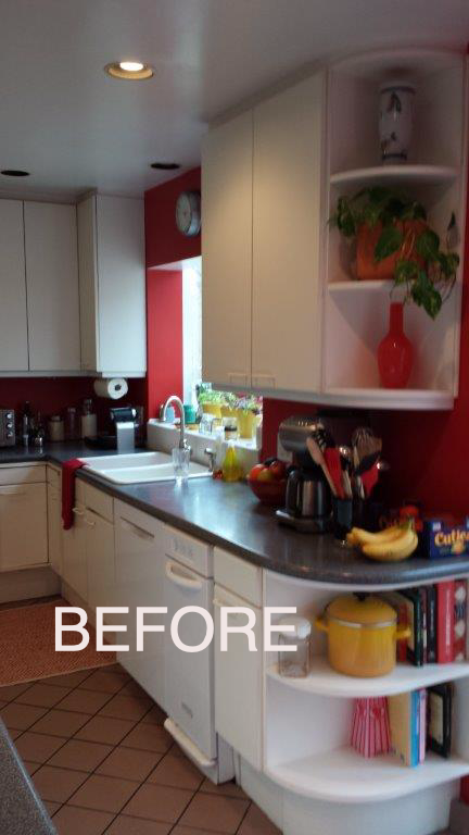 A before picture of a kitchen with red walls and white cabinets