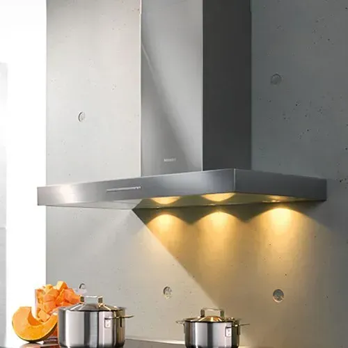 A kitchen with white cabinets , stainless steel appliances , a stove top oven and a refrigerator.