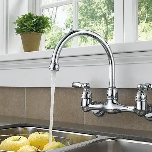 A kitchen sink with a faucet pouring water into it.