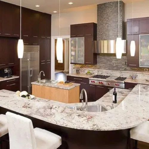 A kitchen with white cabinets and stainless steel appliances and a large island.