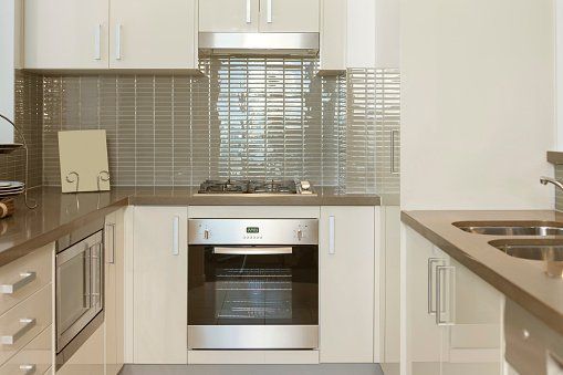 A kitchen with white cabinets and stainless steel appliances