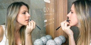 A woman is applying makeup in front of a mirror.