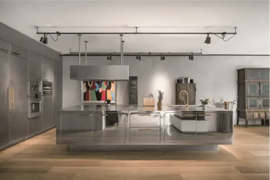 A kitchen with stainless steel appliances and a large island in the middle.