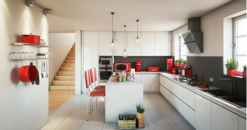 A kitchen with white cabinets and red appliances and a large island in the middle.