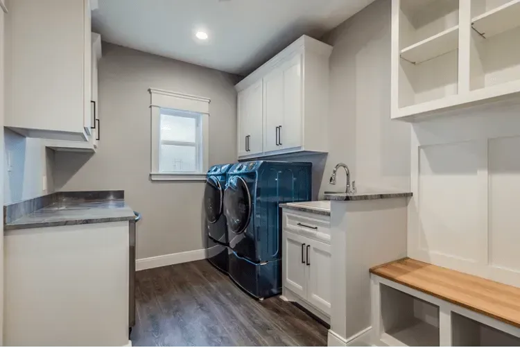 A laundry room with a washer and dryer and a sink.
