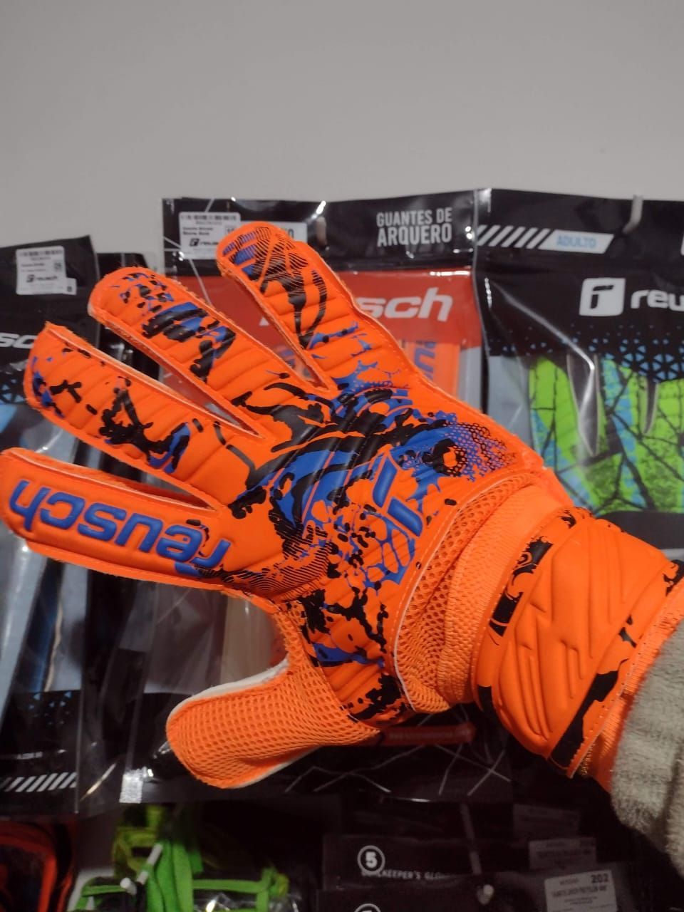 Guantes de portero Reusch color naranja y azul.