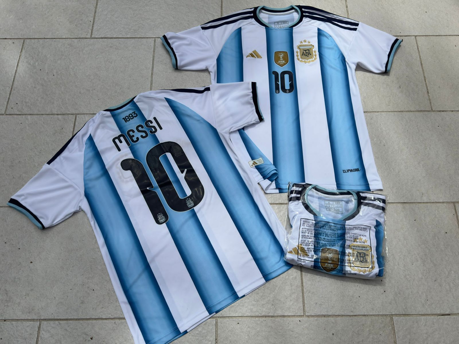 Tres camisetas de fútbol de Argentina con rayas azules y blancas, el nombre de Messi y el número 10 visible.