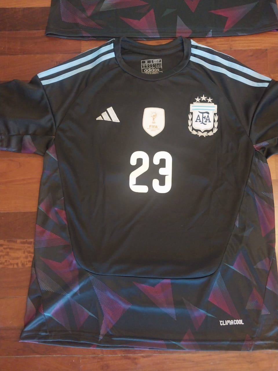 Dos camisetas de fútbol de Argentina, vista frontal y posterior, color negro con detalles en azul, número 23 y 