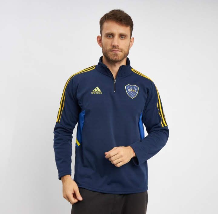 Hombre vistiendo una camiseta de entrenamiento Adidas negra con rayas rojas y el logo de River Plate.