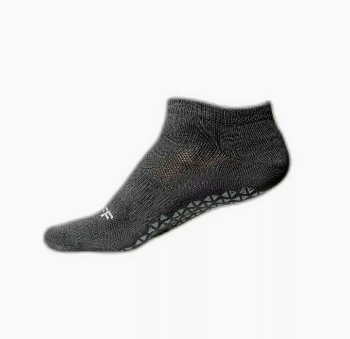 Calcetín tobillero de color gris con puntos de agarre en la suela.