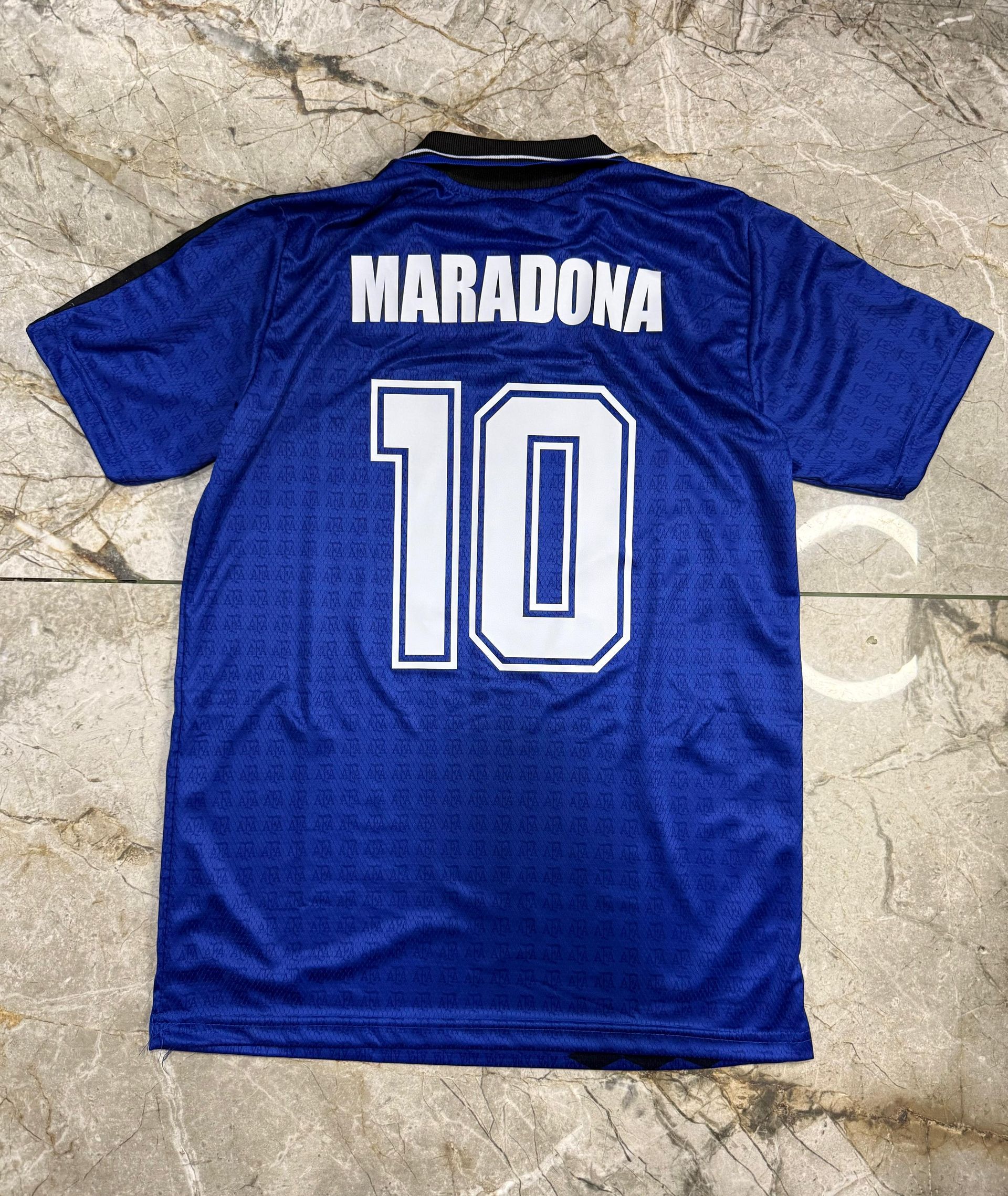 Una camiseta azul de fútbol de Adidas Argentina con cuello negro, estampado lateral negro y el número 10 impreso en la parte delantera.