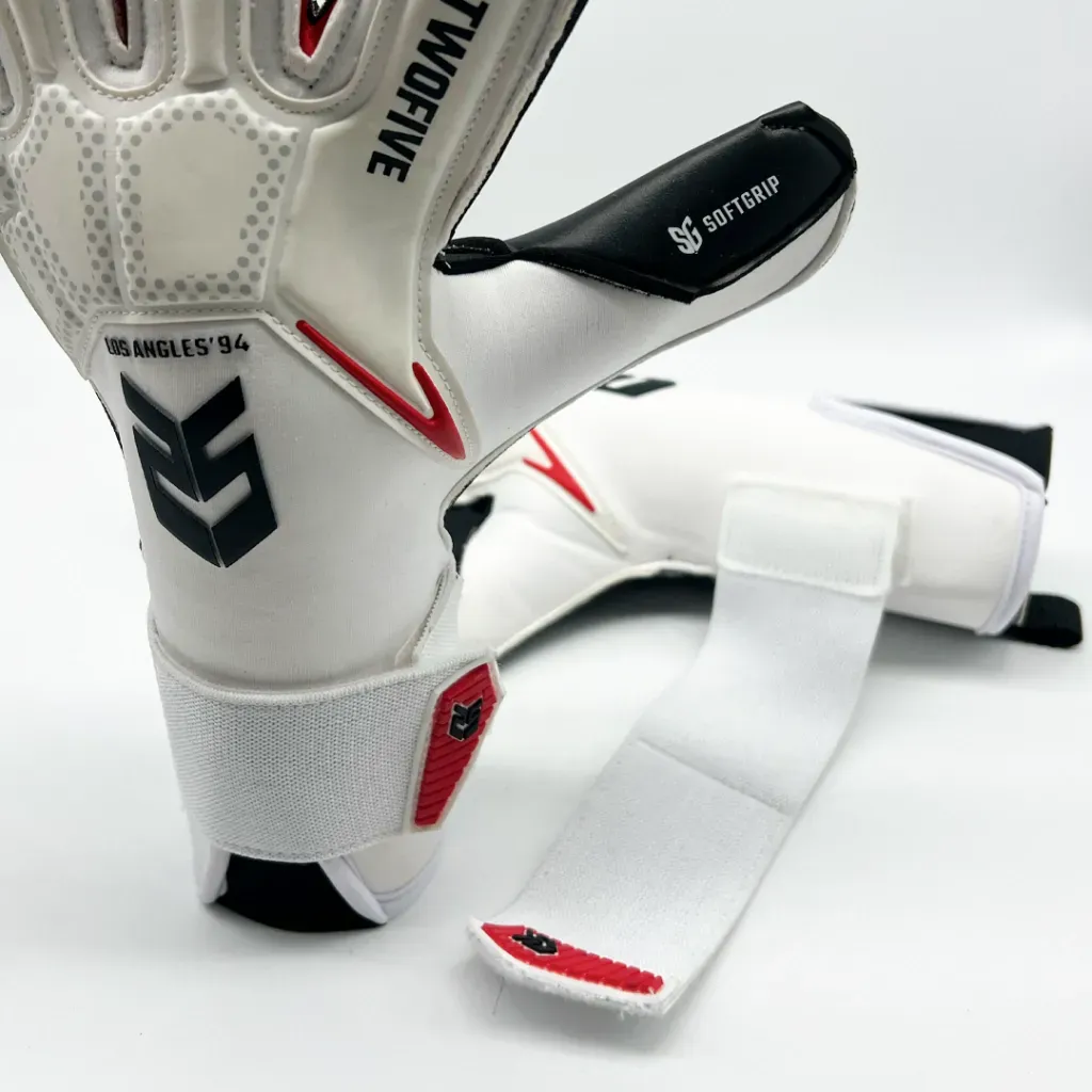 Un par de guantes de portero blancos y negros con el logotipo 