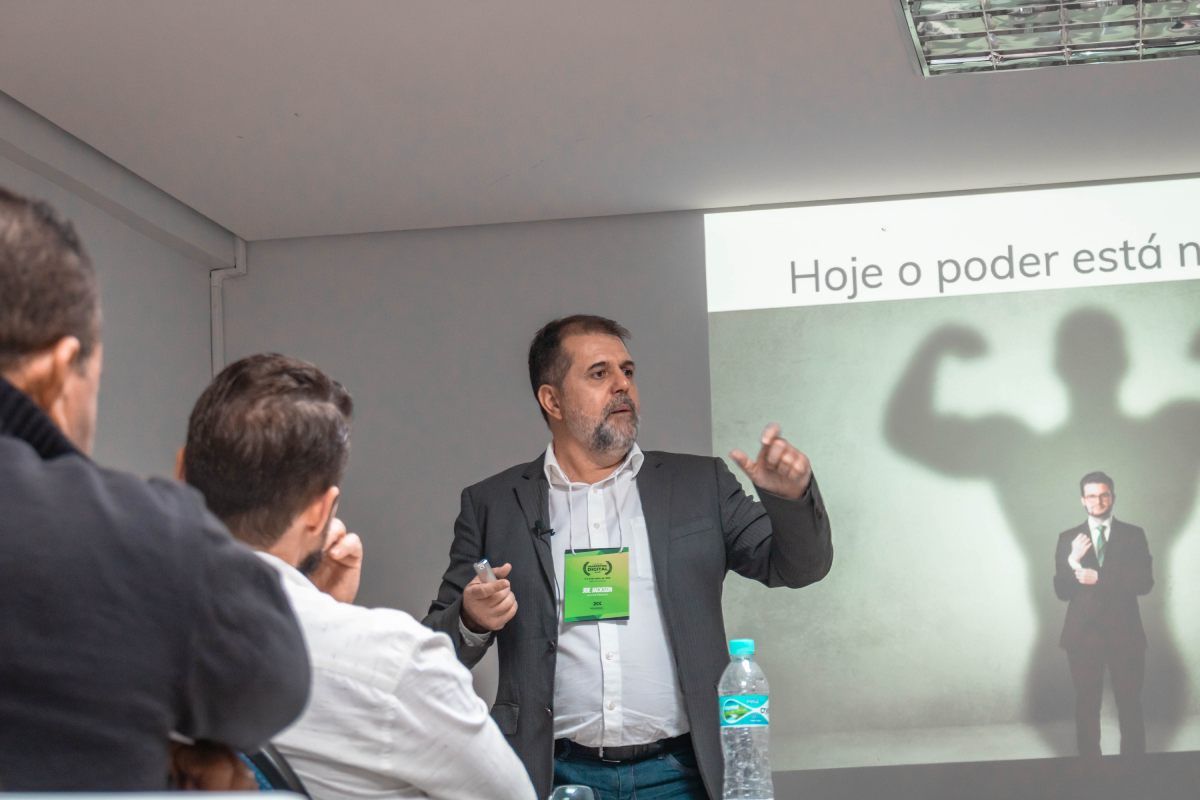 Um homem de terno está fazendo uma apresentação para um grupo de pessoas.
