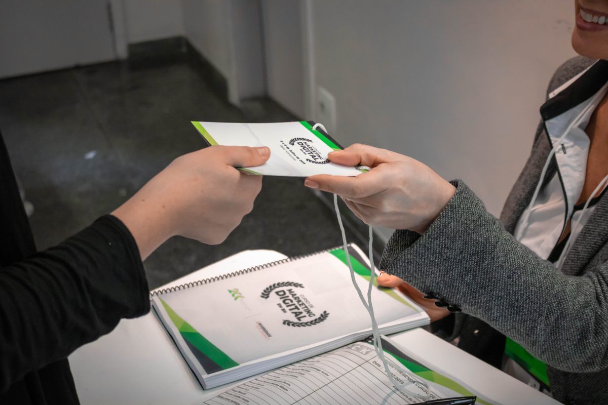 Uma pessoa está entregando um pedaço de papel para outra pessoa